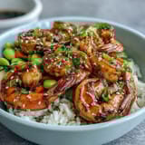 A vibrant Asian Shrimp Bowl featuring juicy grilled shrimp, edamame, and colorful veggies, finished with sesame seeds