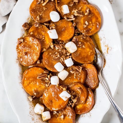 Golden rounds of Candied Yams in a bubbling butter syrup, served warm alongside roast turkey and green beans.