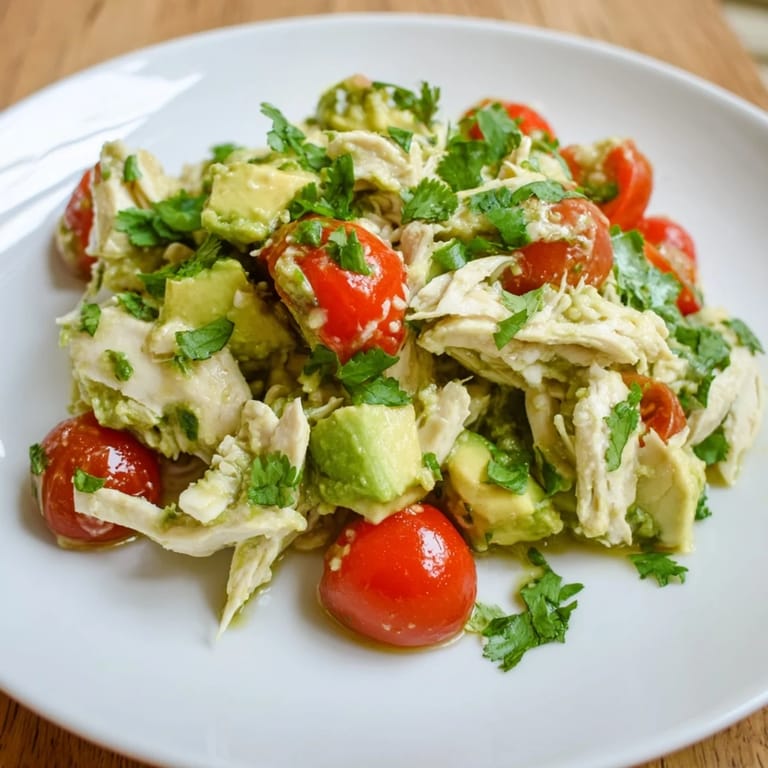 Avocado chicken salad served on whole-grain toast with extra lime wedges for brightness.