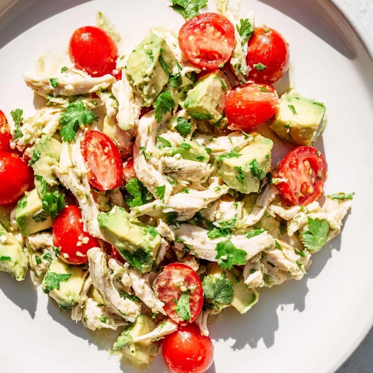 Chilled avocado chicken salad with diced cucumbers and red onion in a rustic setting.